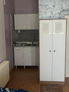 a kitchen with white cabinets and a counter top at Apartman Stil in Kruševac