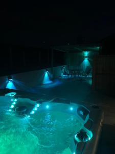 a jacuzzi tub with lights in the dark at Woodburn Lodges in Dumfries