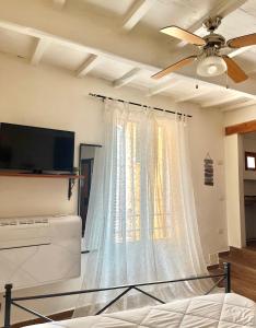 a bedroom with a ceiling fan and a window at La Casa di Alice in Perugia