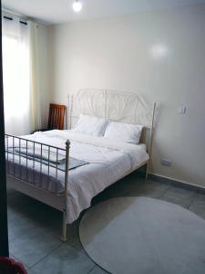 a bedroom with a white bed and a window at Peaceful Paradise in Gatunga