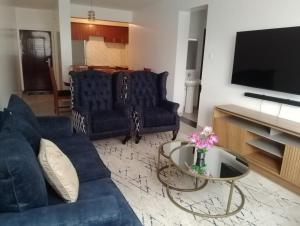 a living room with a blue couch and a table at Peaceful Paradise in Gatunga
