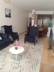 a living room with two blue couches and a table at Peaceful Paradise in Gatunga +20 photos