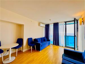 a living room with a blue couch and a table at New Orbi City Luxury Suites in Batumi +36 photos