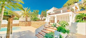 a house with palm trees and a swimming pool at Villa Erika by Solidays in Moraira