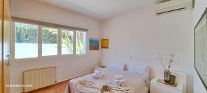 a white bedroom with a bed and a window at Villa Erika by Solidays in Moraira +15 photos