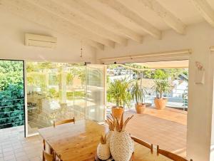 a dining room with a table and some plants at Villa Erika by Solidays in Moraira