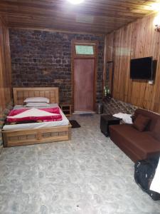 a bedroom with a bed and a couch at Sai Palace in Darjeeling