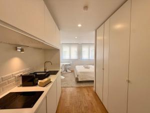 a kitchen with a sink and a bed in a room at B044 Studio moderne Croisette 100m in Cannes