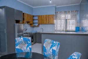 a kitchen with a table and chairs in it at Ritha Motel Apartment in Kigali