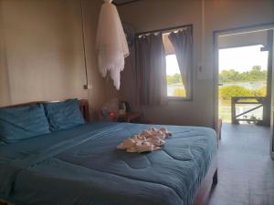 a bedroom with a bed with a towel on it at Champa resort in Don Det