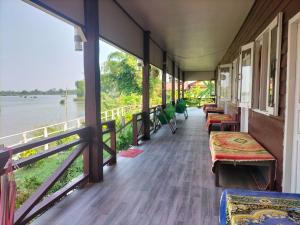 a train hallway with benches and a view of the water at Champa resort in Don Det +17 photos