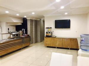 a kitchen with a tv on the wall at Larok Hotel in Akcaabat