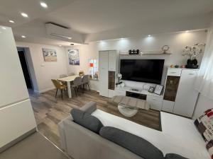 a living room with a white couch and a tv at Apartment Goran in Senj