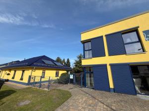 a yellow and blue building next to a building at Ferienwohnungen Seeglück in Senftenberg
