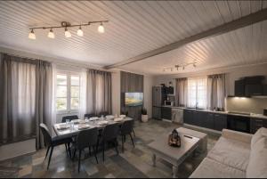 a living room with a dining table and a kitchen at Green Garden Private Villa in Porto Heli