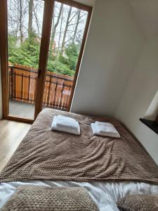 a bedroom with a bed with two towels on it at Miejscówka Werlas in Werlas