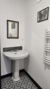 a bathroom with a sink and a mirror on the wall at Le Clos des Souvenirs in Étretat
