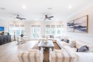 a living room with white furniture and a ceiling fan at Happily Eva After at Prominence 30A in Inlet Beach