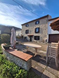 a patio with a table and chairs and a building at Gite Familial aux portes de Foix "Le Coulhòu"- Ariège- 6 personnes in Ferrières-sur-Ariège