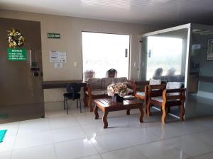 a living room with a couch and a table at Hotel Pousada das Palmeiras in Colíder