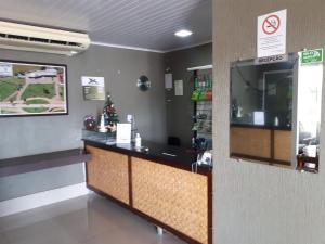 a bar in a waiting room with a christmas tree at Hotel Pousada das Palmeiras in Colíder