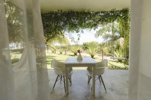 a white table and chairs with a vase on it at Pe na Areia Boutique Hotel in Japaratinga