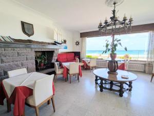 ein Wohnzimmer mit Kamin, Tisch und Stühlen in der Unterkunft Hotel Uhainak in Hendaye