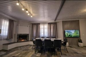 a meeting room with a table and chairs and a fireplace at Green Garden Private Villa in Porto Heli