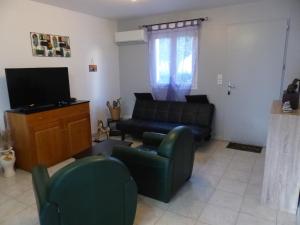 a living room with a couch and a tv at villa Montecristo in Cervione