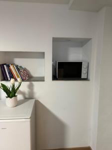 a kitchen with a microwave on a white wall at Studio apartment in Karben