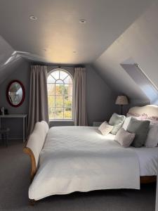 a bedroom with a large bed with a window at The Bothy in Pewsey