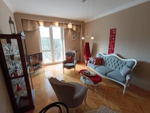 a living room with a blue couch and chairs at Apartament 16 in Sandomierz