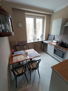 a kitchen with a table and chairs and a window at Apartament 16 in Sandomierz