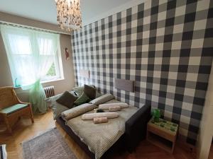 a living room with a couch and a checkered wall at Apartament 16 in Sandomierz