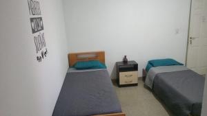 a bedroom with two beds and a nightstand and a bed sidx sidx sidx sidx at Bracco in Chos Malal