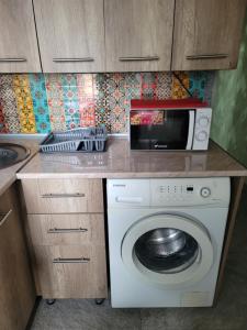 a kitchen with a washing machine and a microwave at Elan apartment in Gori