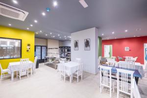 ein Restaurant mit Tischen und Stühlen und einer gelb-roten Wand in der Unterkunft Mega Hostel in Sarandë