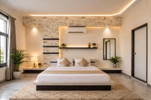 a bedroom with a large white bed and a brick wall at Hotel Nomadic in Udaipur +39 photos