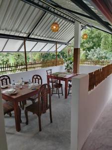 a dining area with tables and chairs on a patio at Robert Ayurveda Villa in Bentota