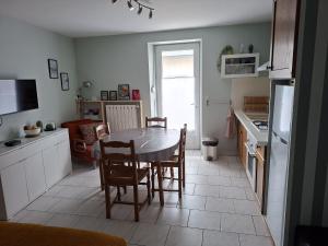 a kitchen with a table and chairs in a room at Appartement Véronica - Villa Damary in La Bourboule +7 photos