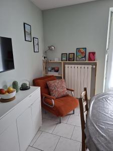 a living room with a chair and a bed at Appartement Véronica - Villa Damary in La Bourboule