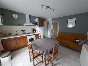 a kitchen and living room with a table and a couch at Appartement Véronica - Villa Damary in La Bourboule