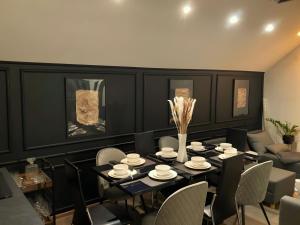 a black dining room with a table and chairs at Empyrean House in Dišnik