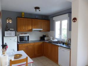 a kitchen with wooden cabinets and a white refrigerator at villa Montecristo in Cervione