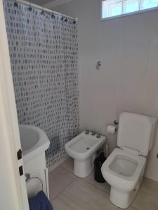 a white bathroom with a toilet and a sink at Salvia in Trenque Lauquen