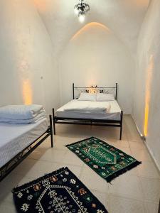 a bedroom with two beds and two rugs on the floor at Ro House in Mardin