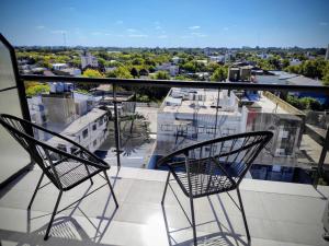 two chairs on a balcony with a view of a city at Salvia in Trenque Lauquen
