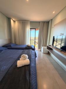 a hotel room with two beds with towels on them at BobZ Concept in Barrinha