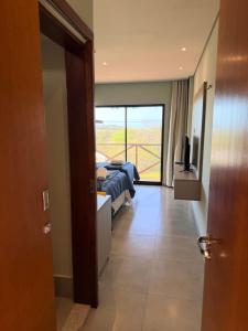 a bedroom with two beds and a balcony at BobZ Concept in Barrinha