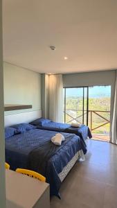 a bedroom with two beds and a balcony at BobZ Concept in Barrinha